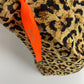 Close-up foto van de luiertas met panterprint waarbij het oranje lintje goed zichtbaar is. Het oranje lintje met koper gedrukte letters is kenmerkend voor de BAERE AMSTERDAM luiertas. 
